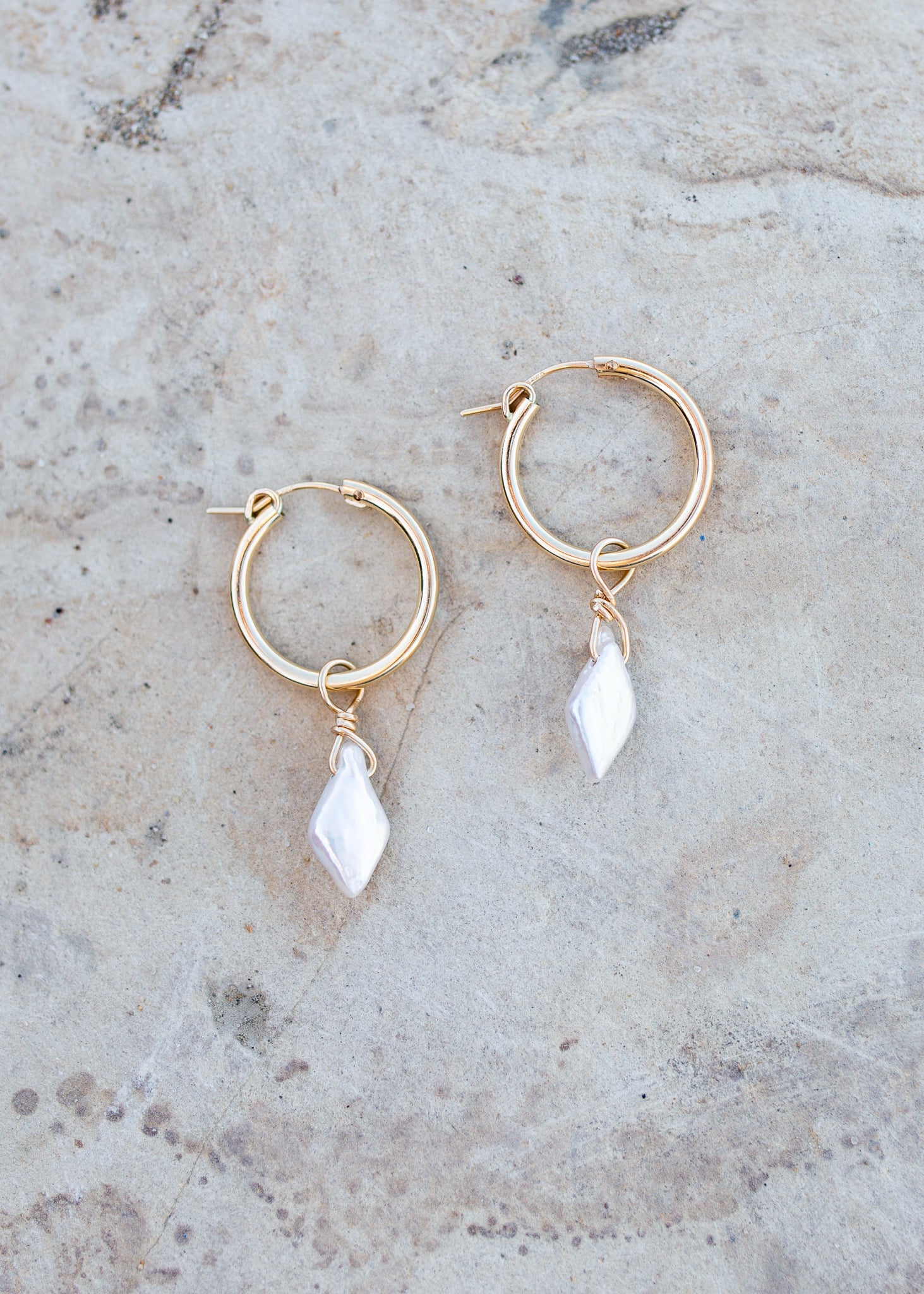 Gold hoop earrings with a single diamond shaped freshwater pearl