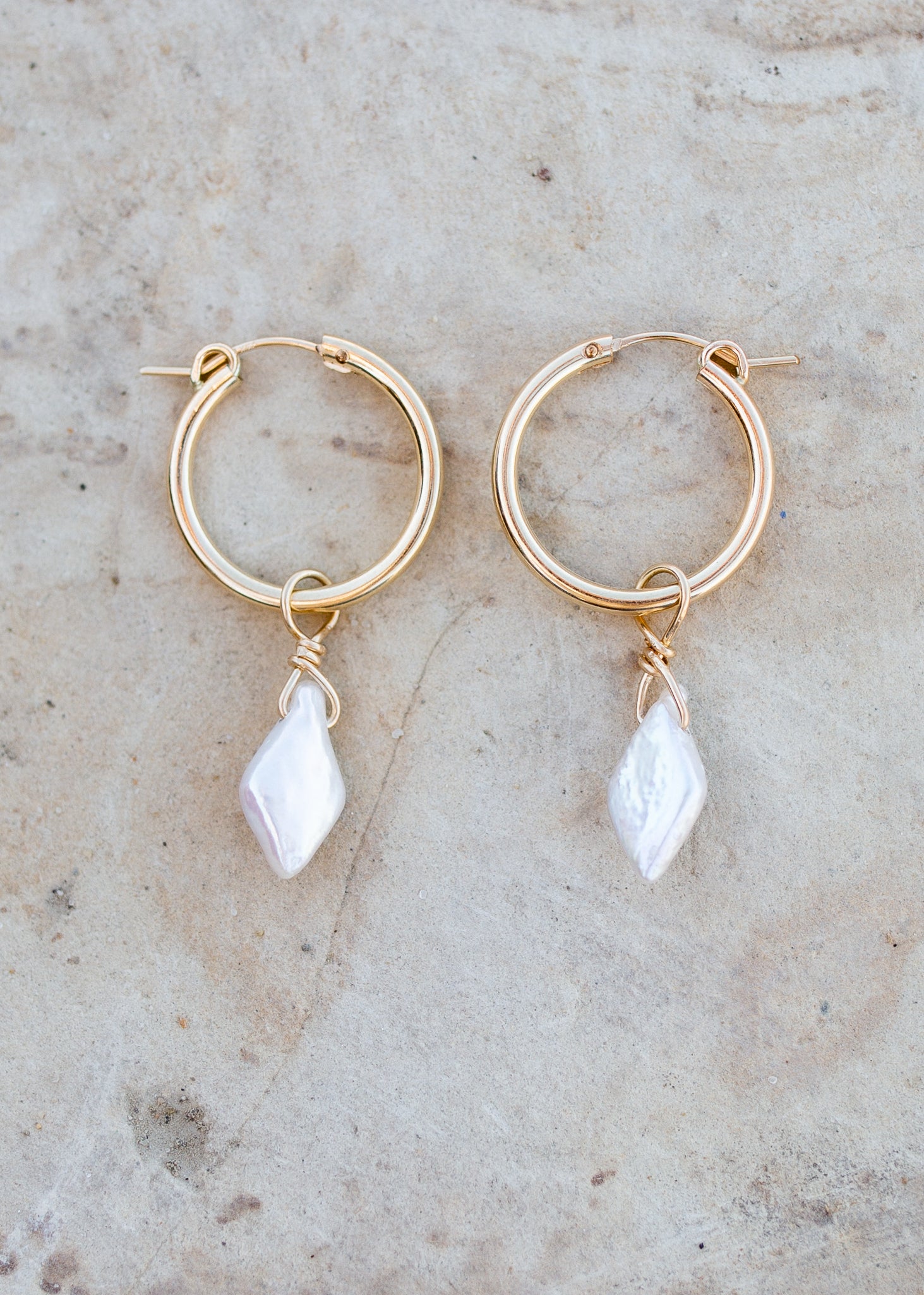 Gold hoop earrings with a single diamond shaped freshwater pearl