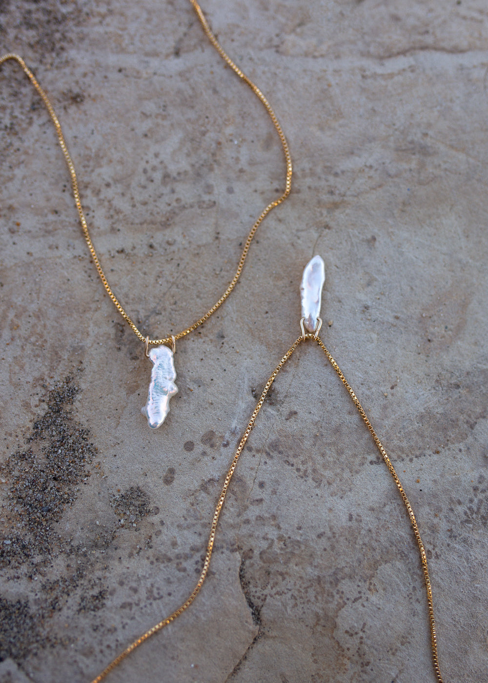 Three Elara necklaces side by side to show the variation in natural pearl pendants used.