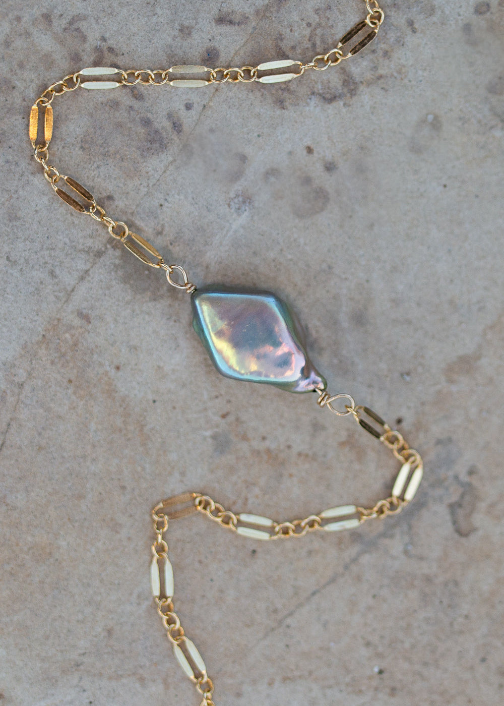 Bracelet with dapped sparkly gold chain and a stunning rainbow green/purple diamond shaped pearl in the center.