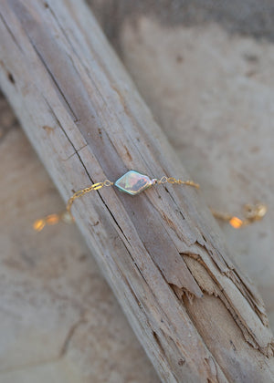 Alternate view of the bracelet draped over a piece of driftwood