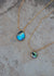 Close up view of venetian gold chain with abalone pendants in large and small sizes. Abalone pendants are iridescent blue and green rainbow swirls.