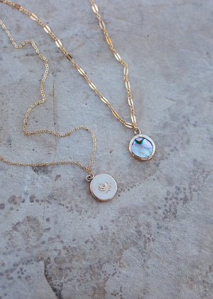 Side by side of the back of the pendant with a moon & star stamp, and the front of the pendant with vintage abalone.