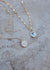 Side by side of the back of the pendant with a moon & star stamp, and the front of the pendant with vintage abalone.