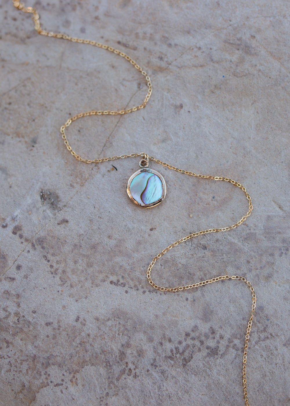 Abalone set in a round gold bezel with a dainty cable chain