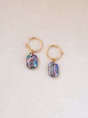 Gold hoop earrings with colorful pearl nuggets on a light background