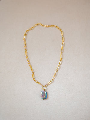Gold chain necklace with a rectangular peacock blue rainbow pearl pendant.
