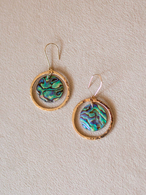 Pair of earrings with thick gold circles surrounding blue and green abalone coins