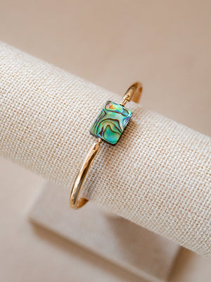 Gold banded bracelet with a rectangular abalone piece 