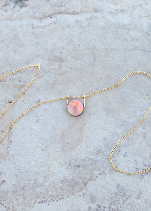 The front side of the mother of pearl coin with a deeper rainbow iridescent sheen