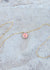 The front side of the mother of pearl coin with a deeper rainbow iridescent sheen