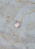 Circular mother of pearl coin with a gold sliding bail and dainty gold cable chain