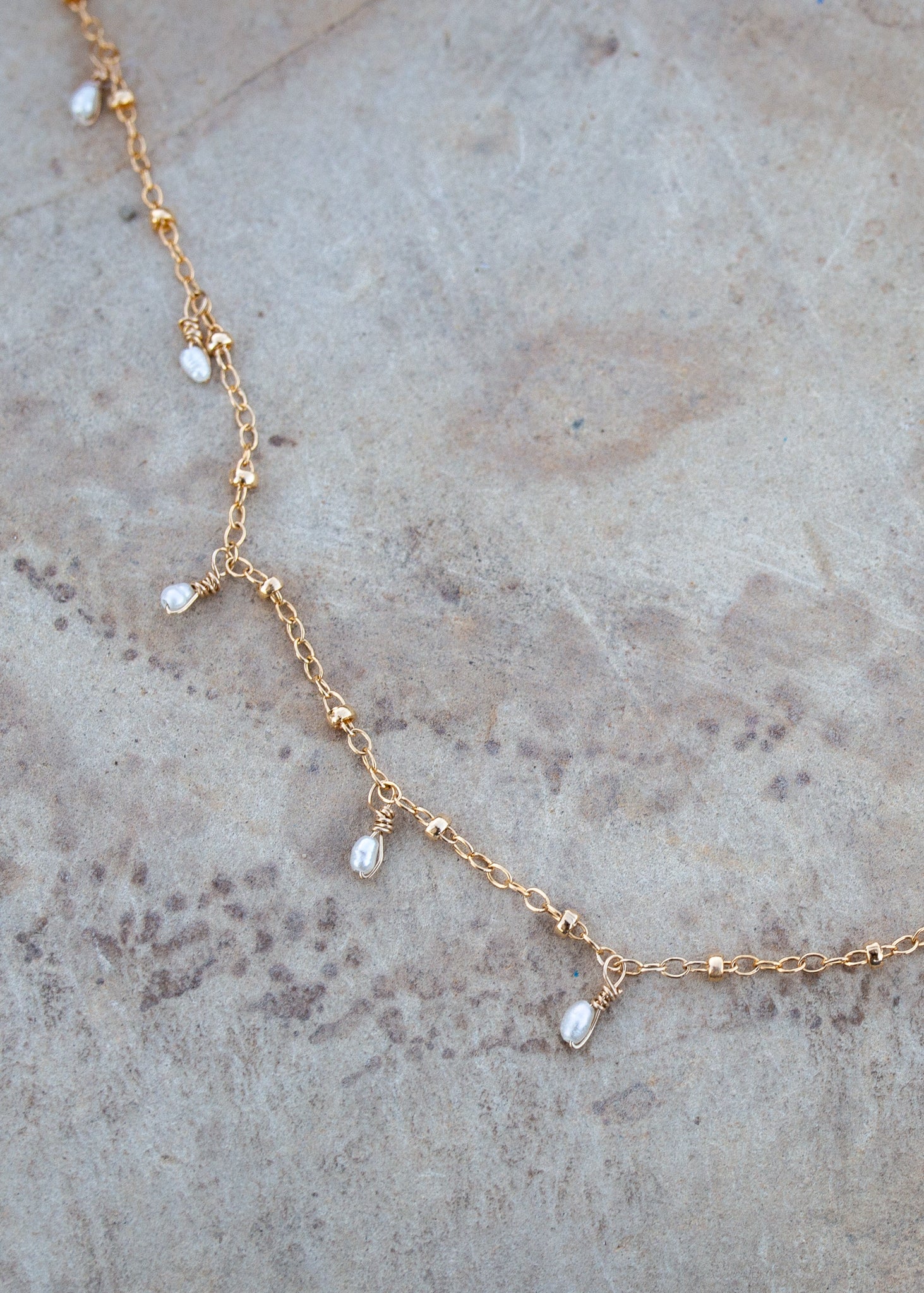 Gold chain with small pearls dotting the length