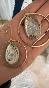 Shows a video clip comparing the original Crystal Cove earrings vs the larger LUXE version